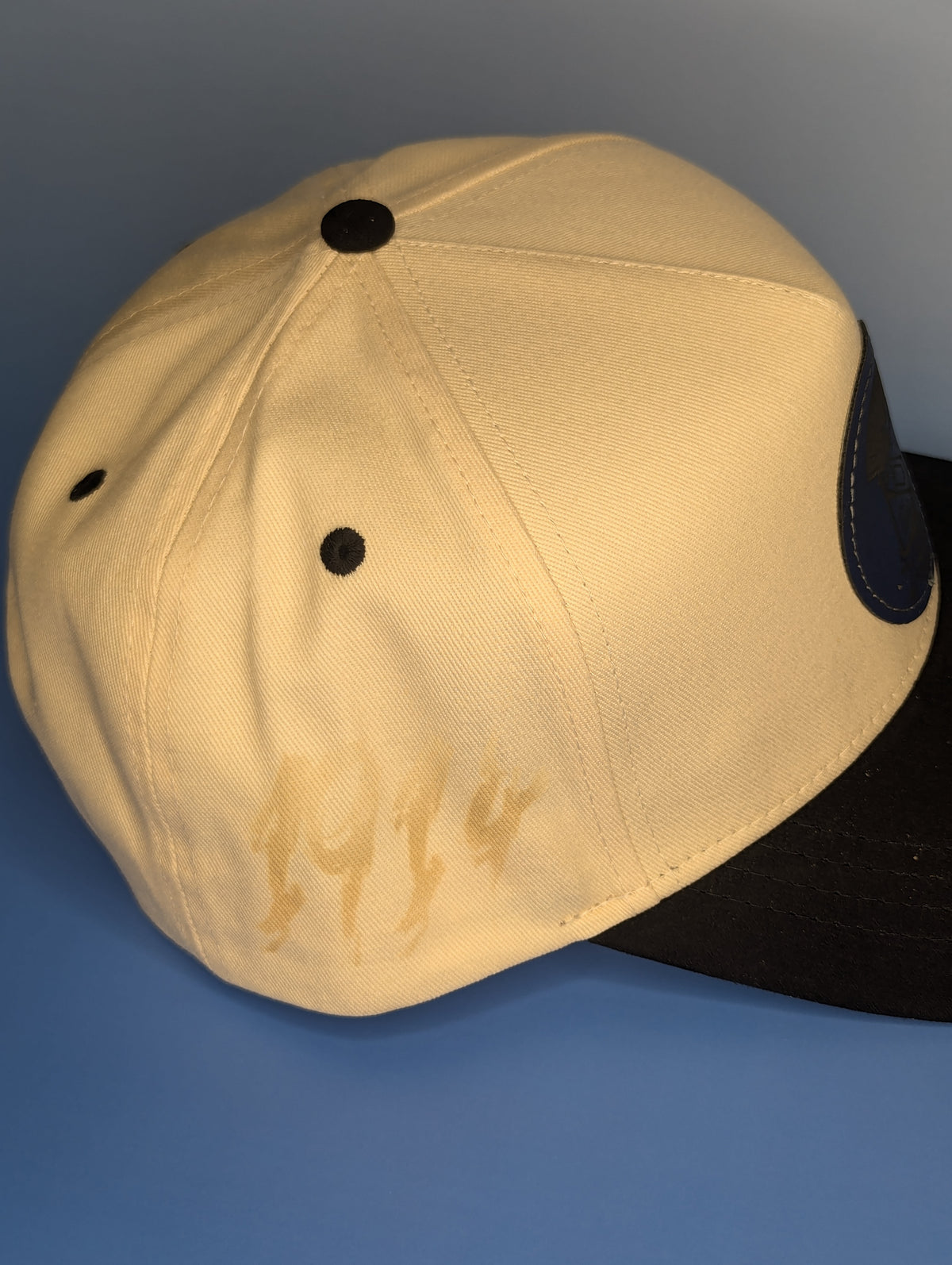beige hat with black suede bill