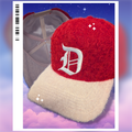 Red and cream satin-lined fur hat with a white 'D' embroidered on it