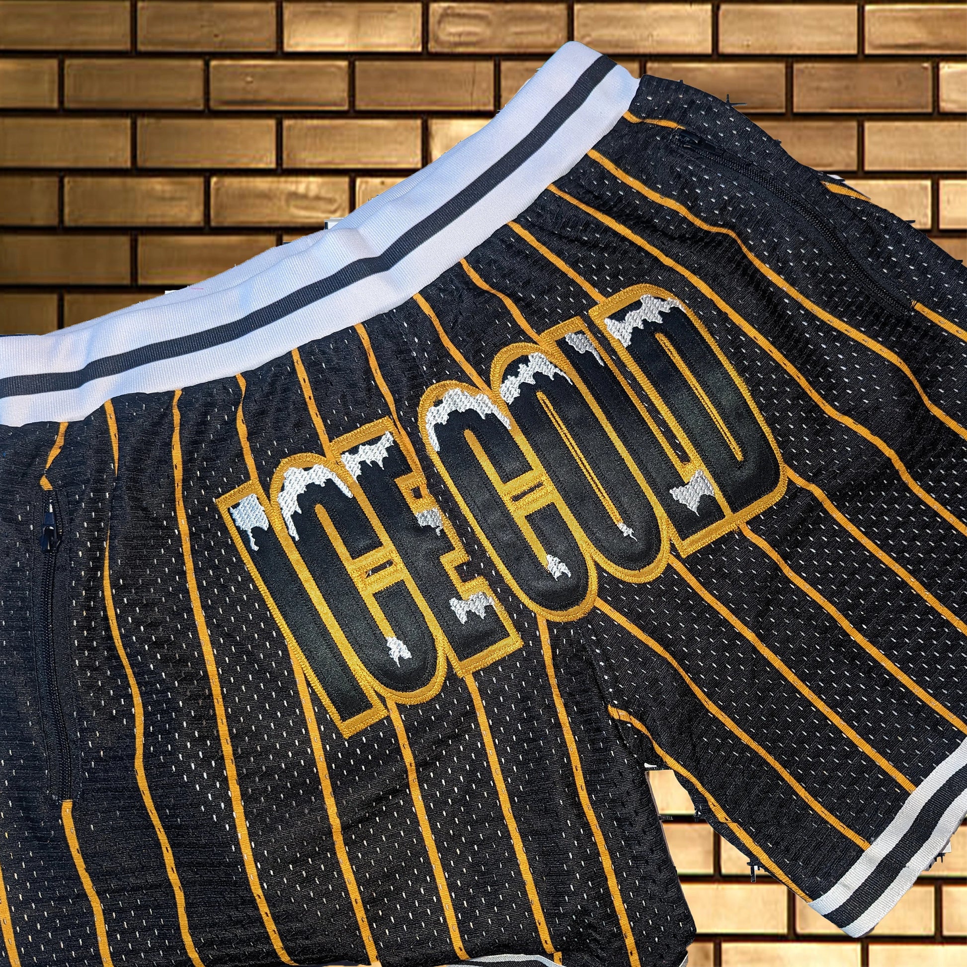 Black and gold sports jersey with 'ICE COLD' text against a brick wall background