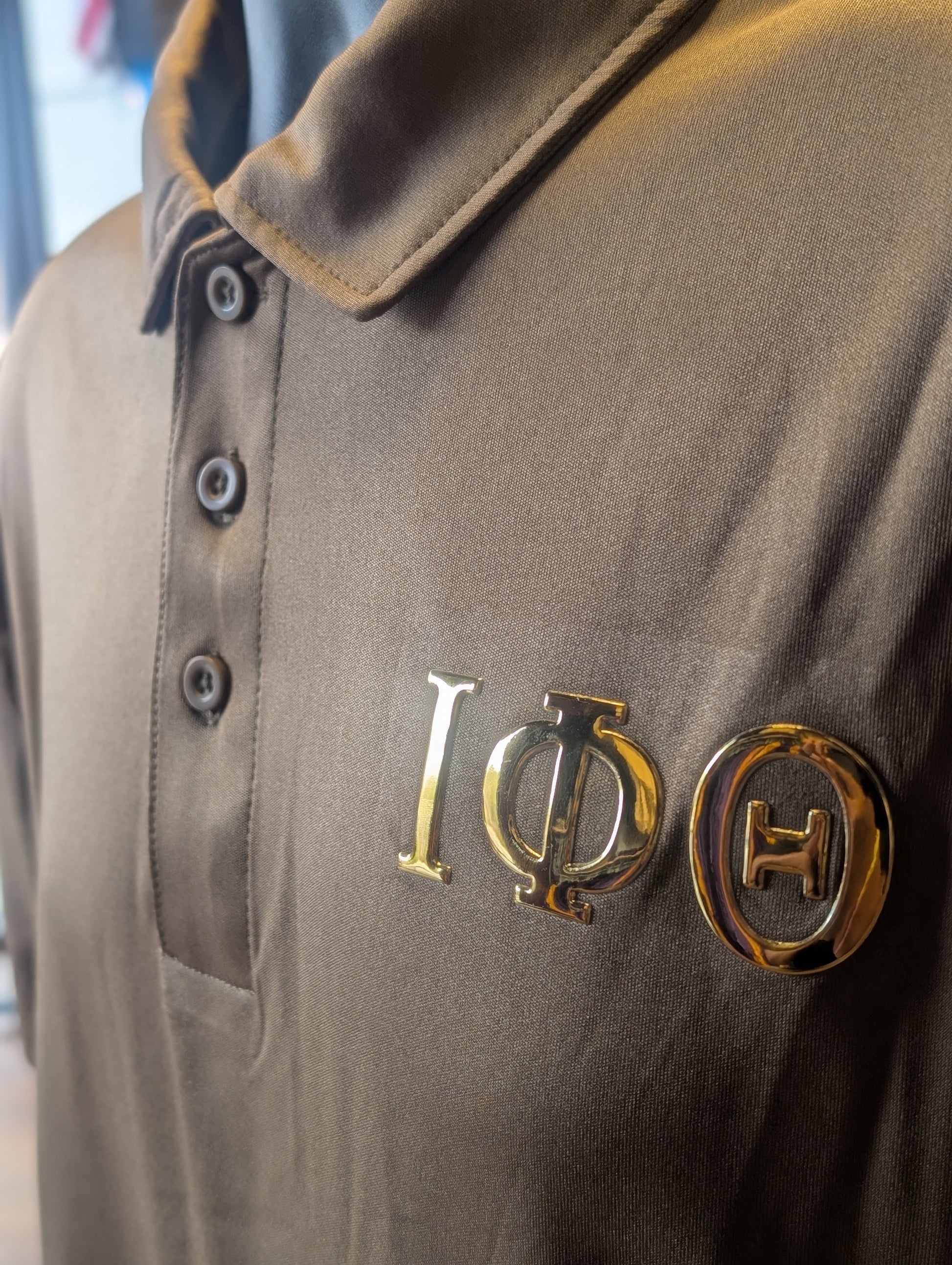 Brown polo shirt with gold greek letters iota phi theta on the left chest