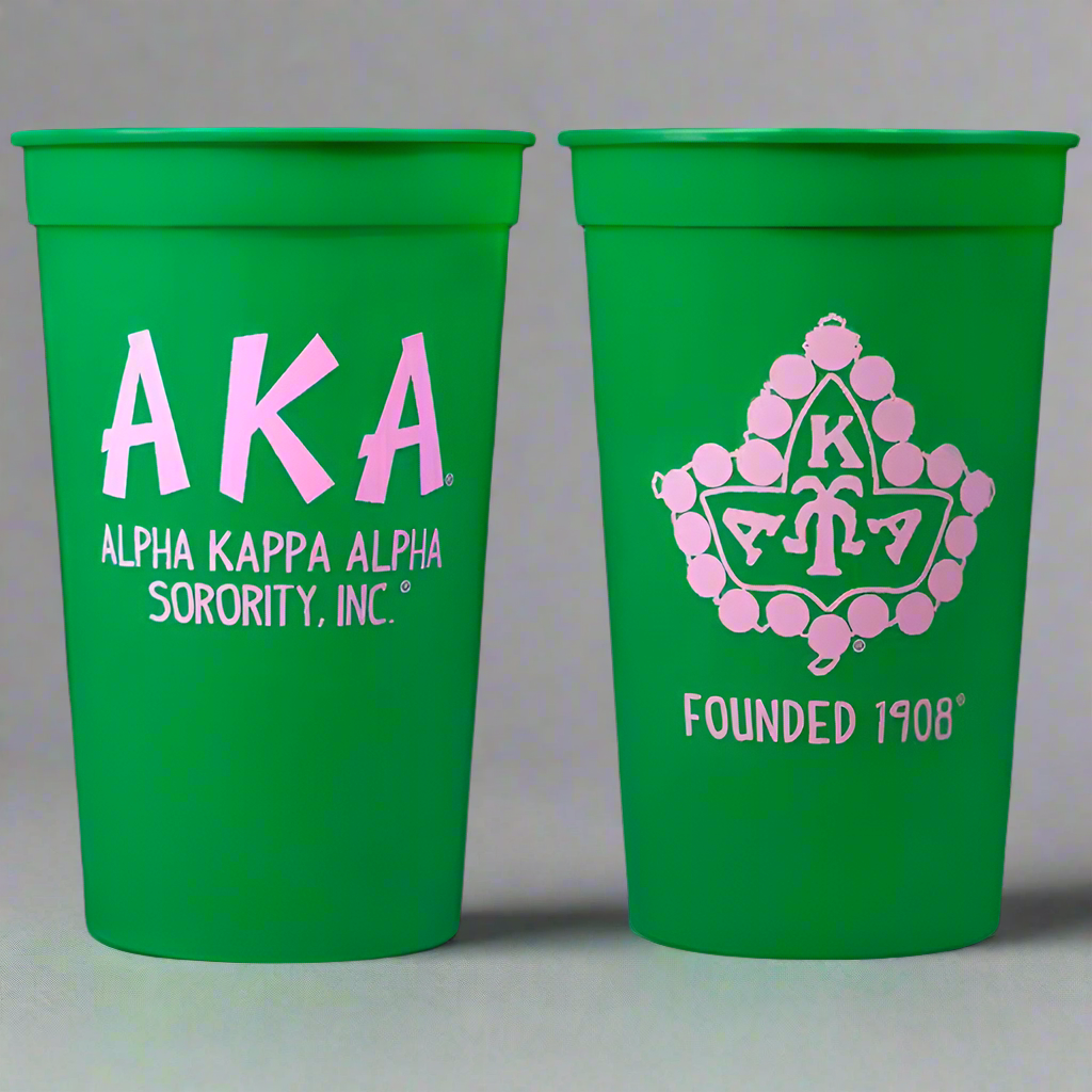 Two green cups with Alpha Kappa Alpha sorority logos on a gray background