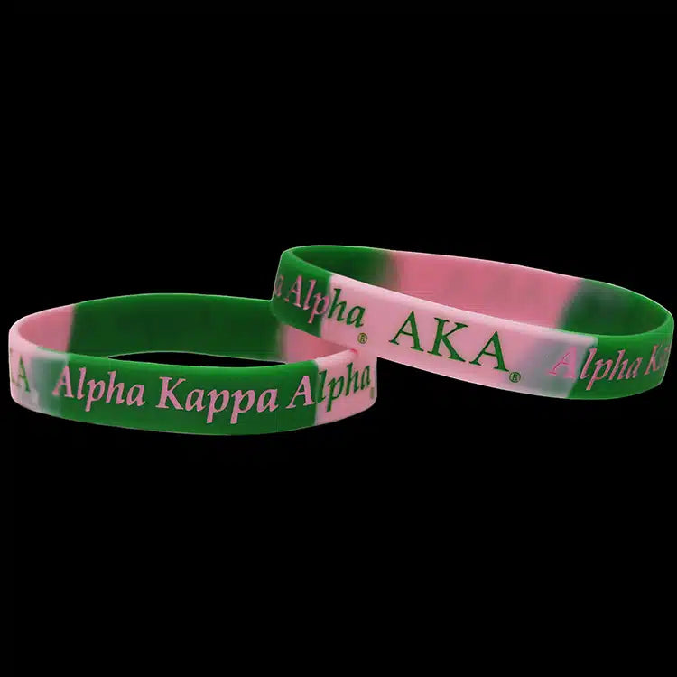 Two green and pink 'Alpha Kappa Alpha' wristbands on a black background