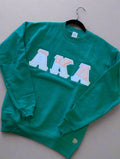 Green sweatshirt with 'AKA' letters