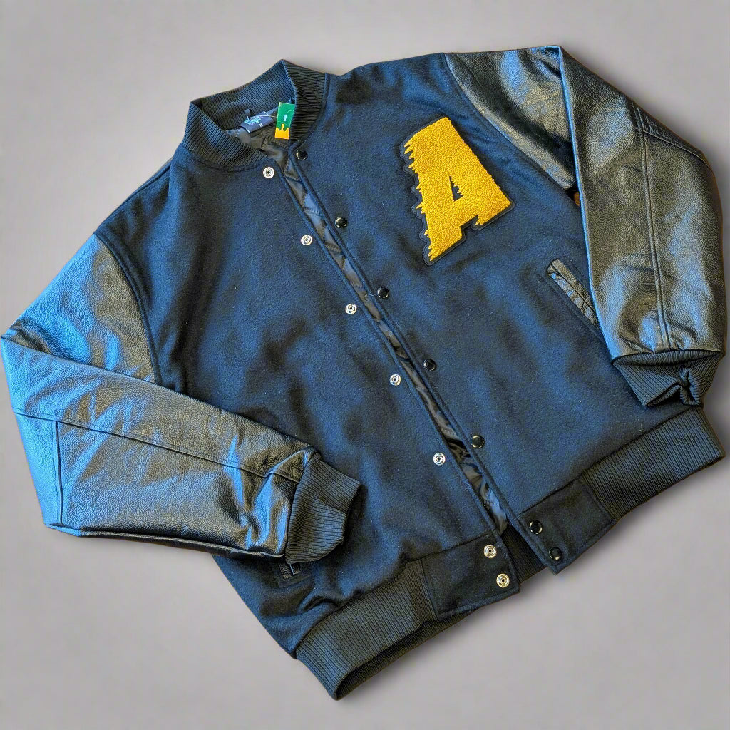 Black varsity jacket with a yellow letter 'A' on a wooden surface