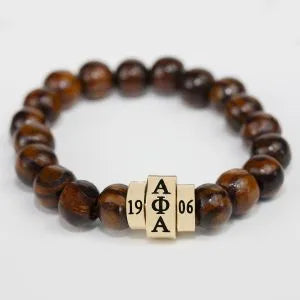 Wooden beaded bracelet with a gold clasp featuring alpha greek letters and founding year