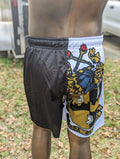 Person wearing black and white shorts with a lion emblem on grass.