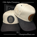Two baseball caps with leather patches on a black background, featuring '1906 Alpha ' text.