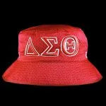 Red bucket hat with white Greek letters on a black background