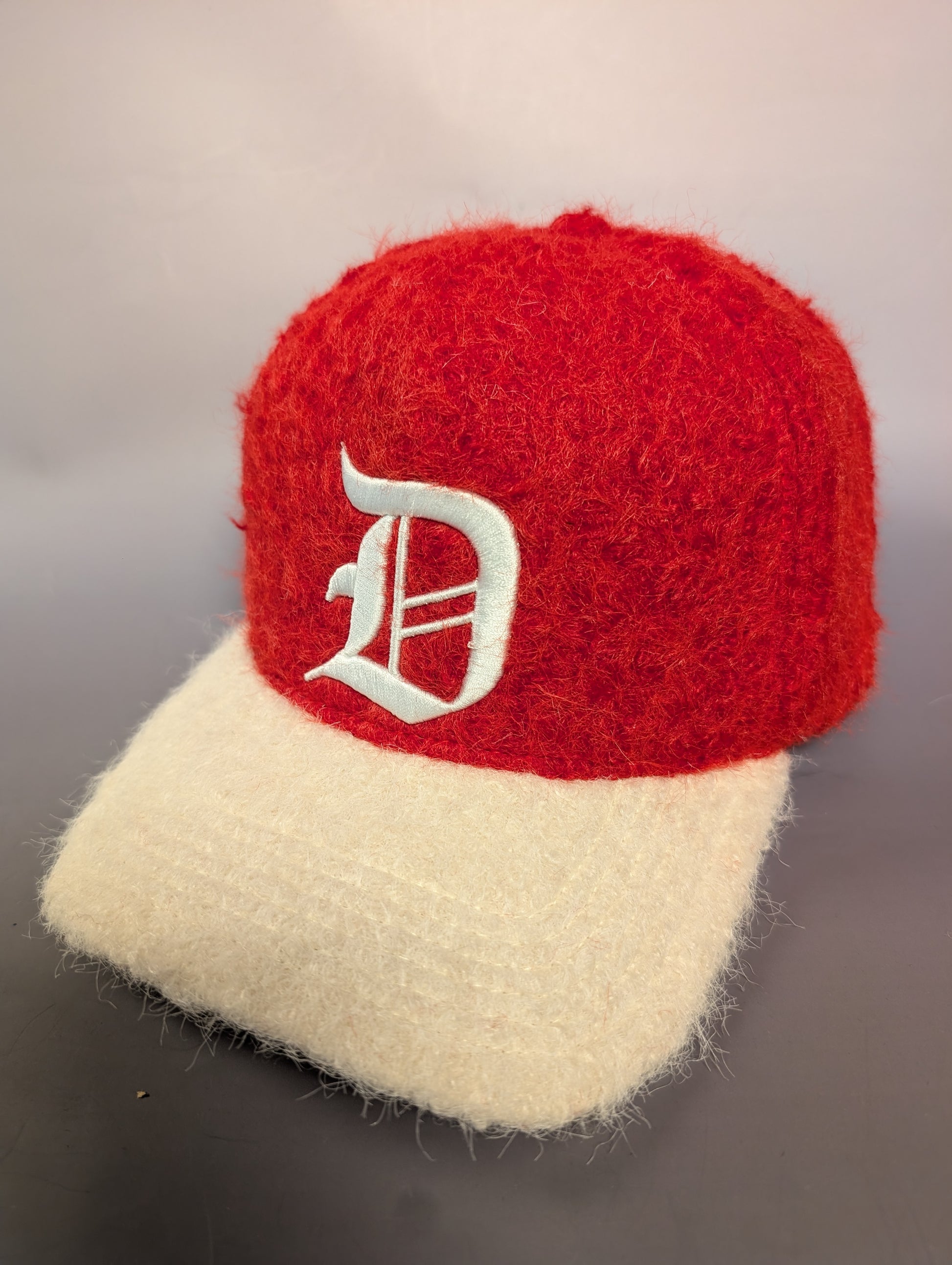 Red and cream hat with a 'D' embroidered 