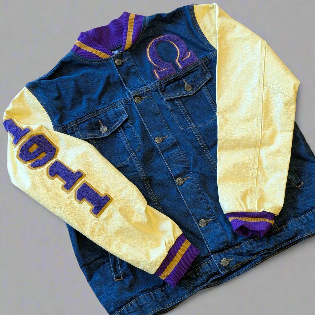 Denim letterman jacket with yellow and purple accents on a wooden surface