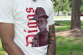 White t-shirt with a graphic design of a person wearing a hat and text, outdoors.