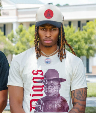 Two A-frame caps with suede brims, one in beige and the other in a darker color, featuring pins and an engraved design on the front.