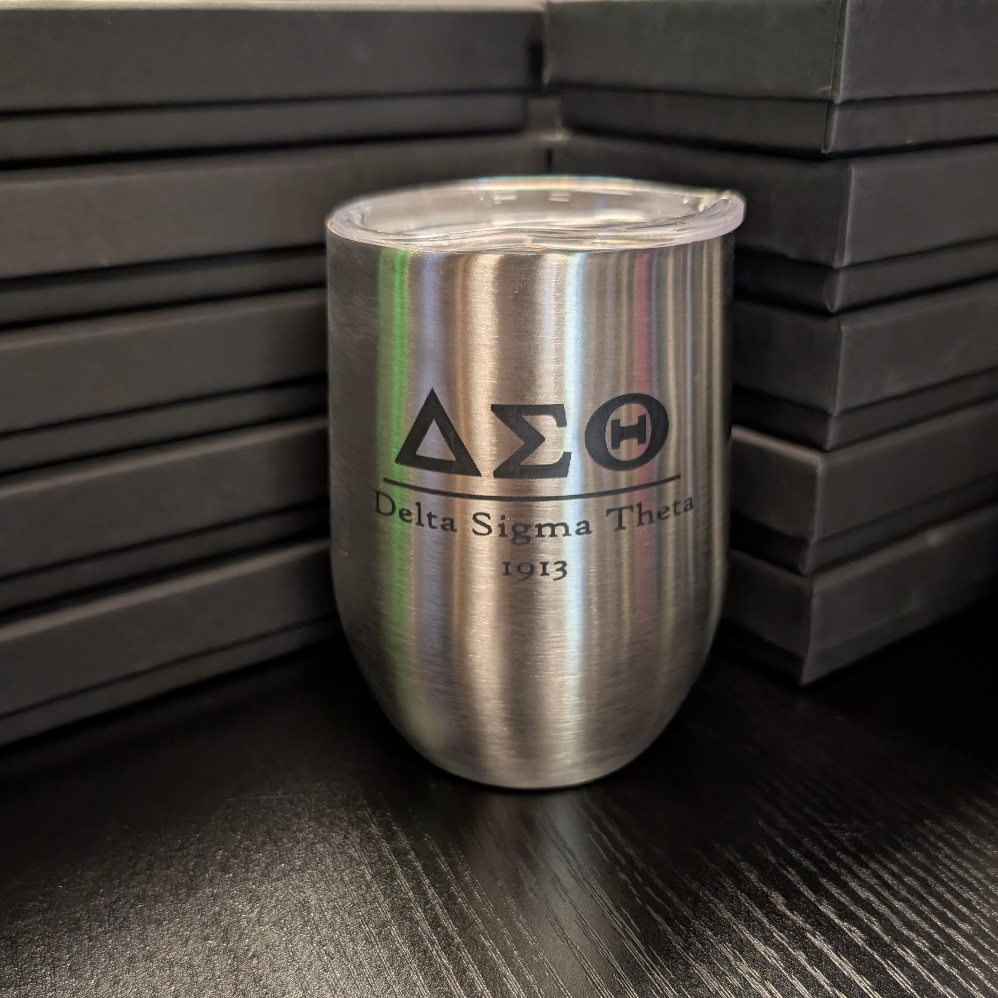 Silver tumbler with Delta Sigma Theta logo on a dark surface