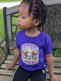 Child wearing a purple t-shirt with 'Future Omega' and bulldog graphics, sitting on a wooden bench.