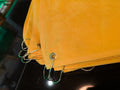 Yellow fabric with metal hooks on a dark background