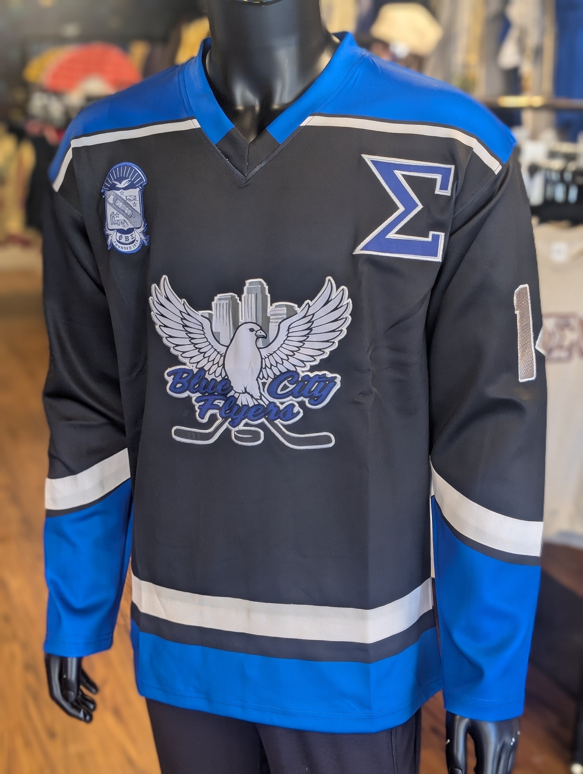 Black hockey jersey with blue accents and logos on a mannequin