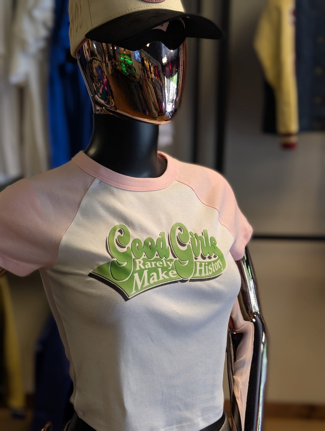 Mannequin wearing a t-shirt with 'Good Girls Rarely Make History' text in a casual setting.