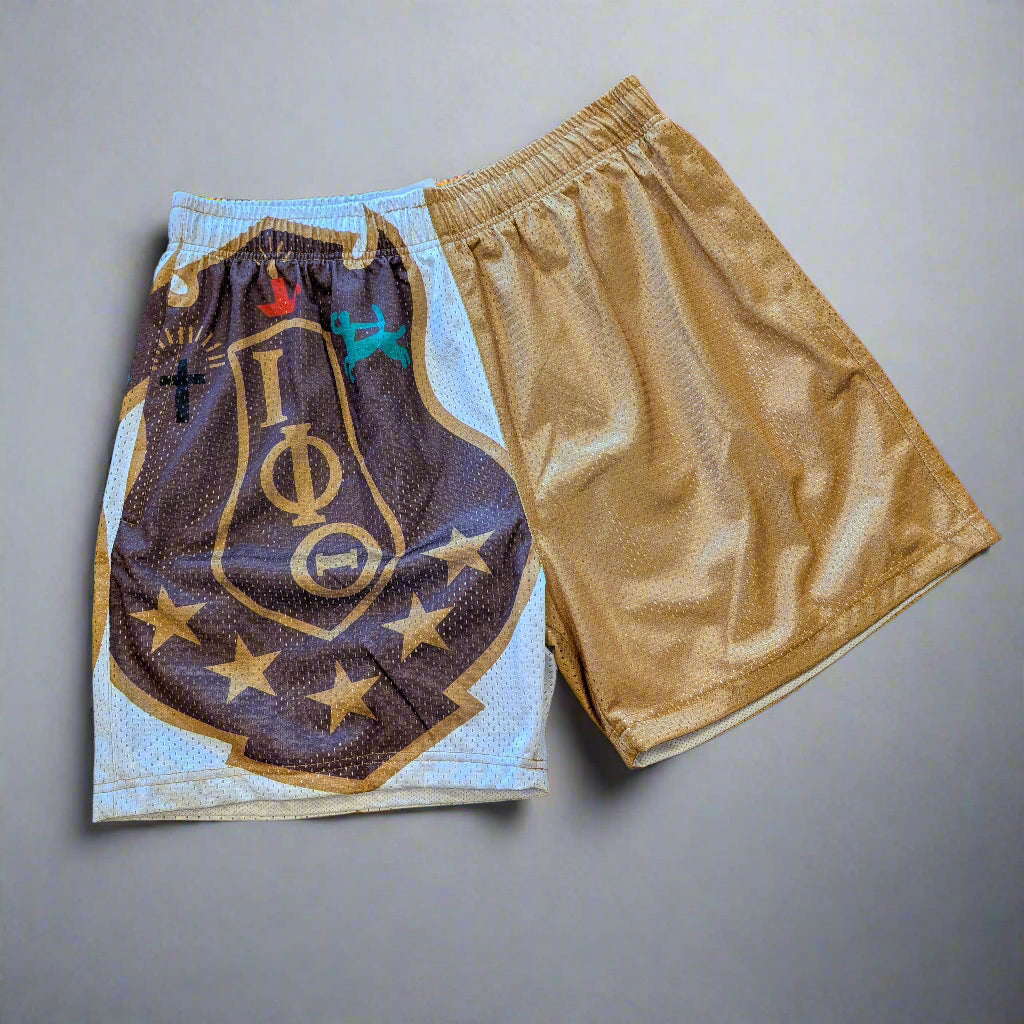 Two pairs of shorts on a wooden floor, one with a logo design and the other plain.