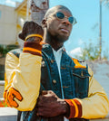 Man wearing an iota phi theta denim varsity jacket with chenille accents.