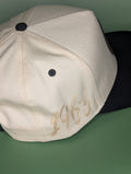 beige hat with black suede bill