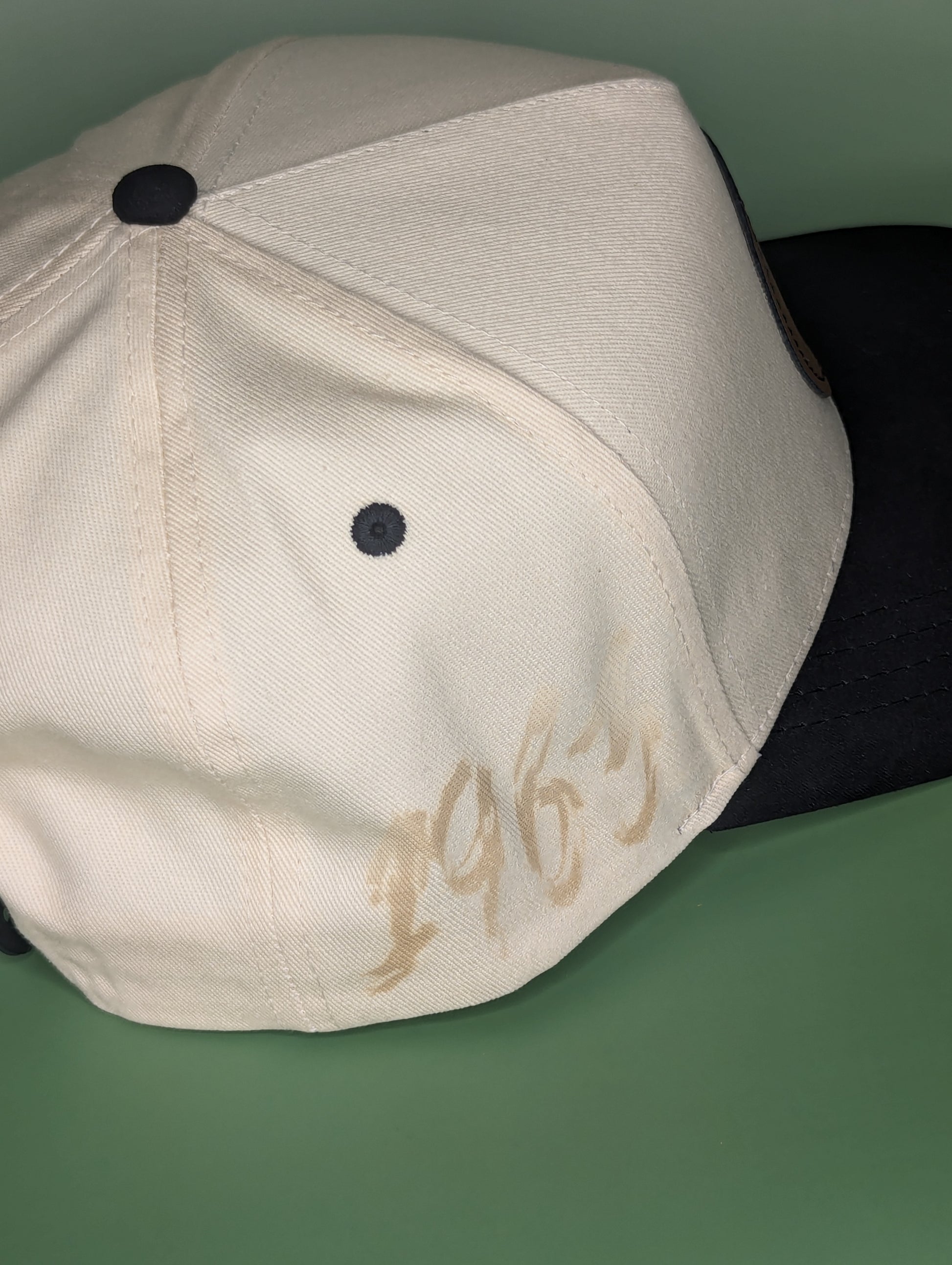 beige hat with black suede bill