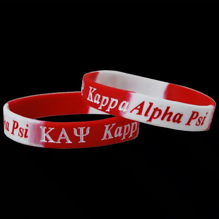 Two red and white wristbands with 'Kappa Alpha Psi' text on a black background