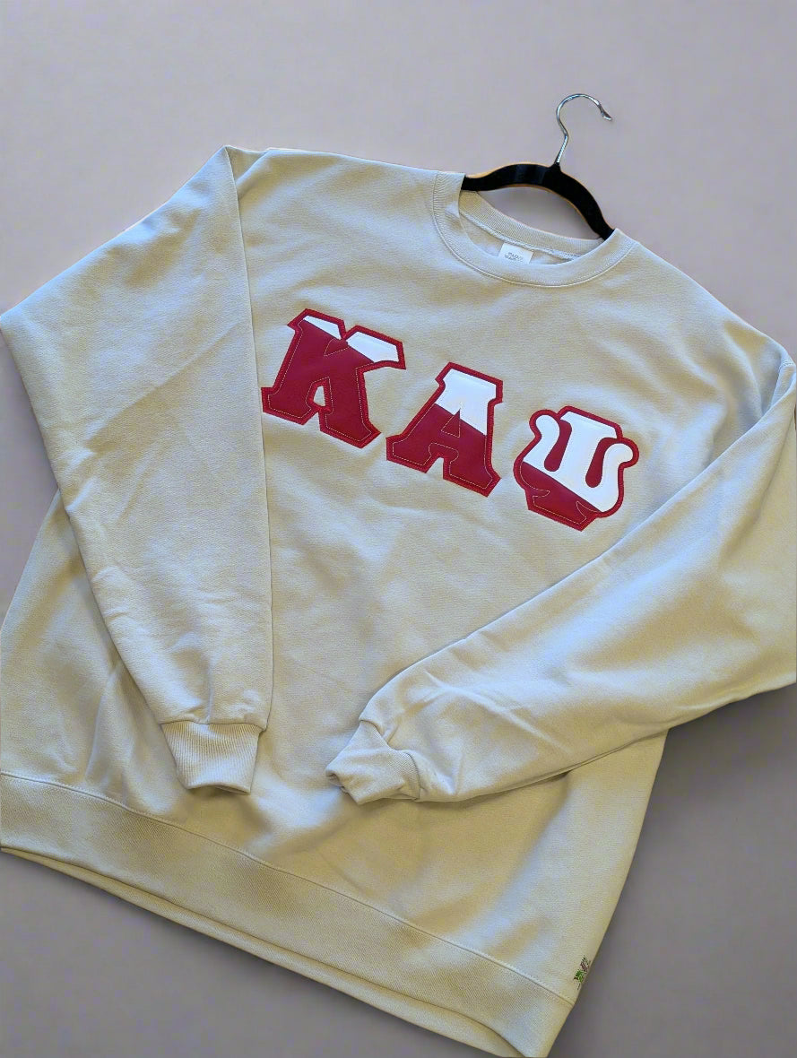 cream sweatshirt with red text on a plain background