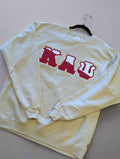 cream sweatshirt with red text on a plain background
