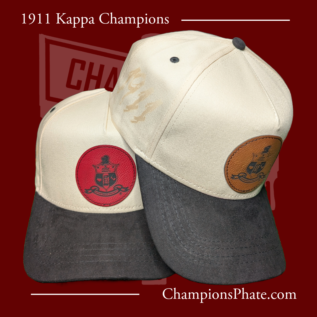 Two A-frame caps with suede brims, one in beige and the other in a darker color, featuring pins and an engraved design on the front.