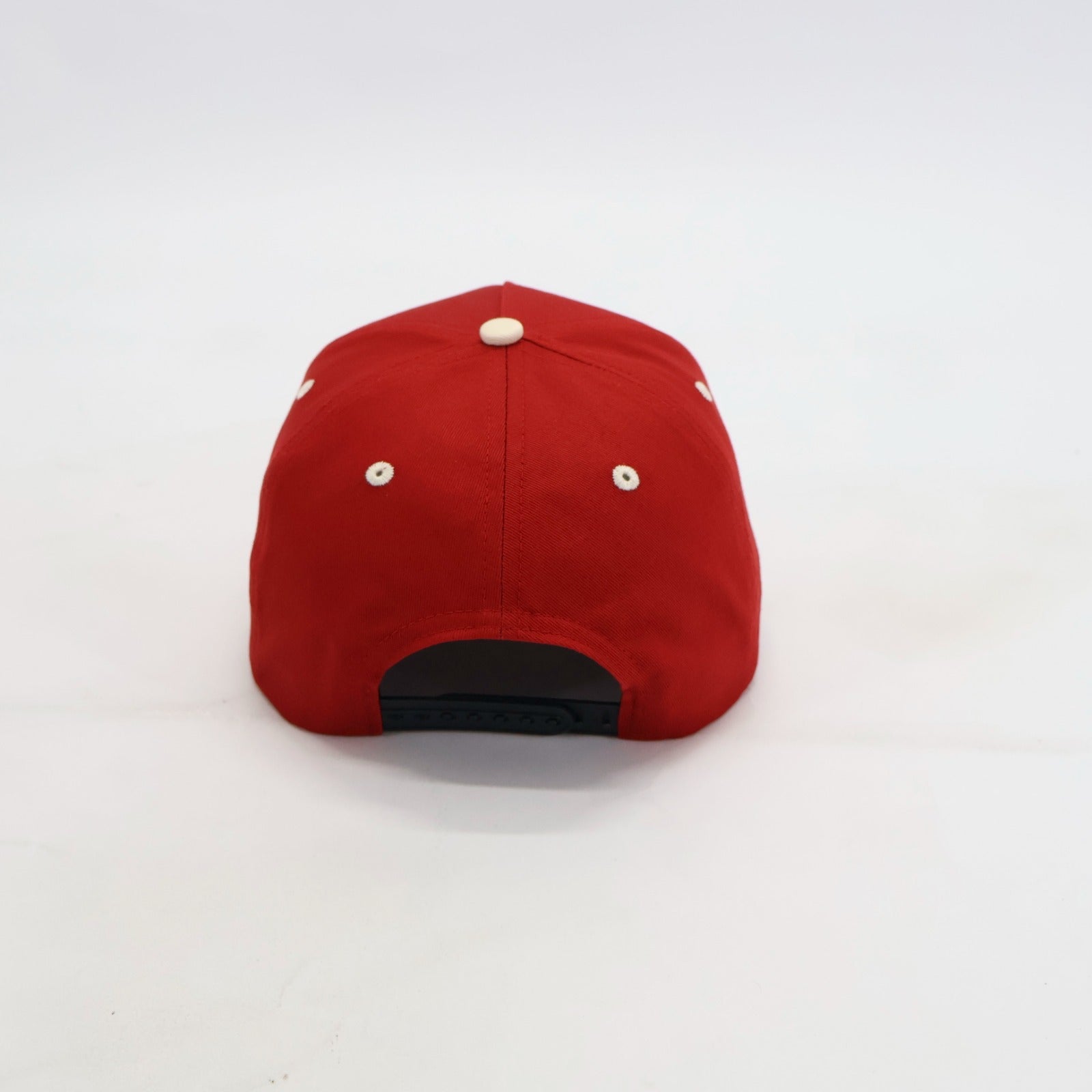Red cap with cream eyelets on a white background