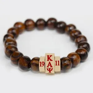 Brown wood beaded bracelet with a cube charm featuring 'Kappa Alpha Psi' letters and founding year