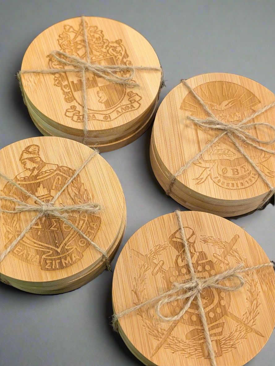 Set of wooden coasters with engraved designs tied together on a black surface