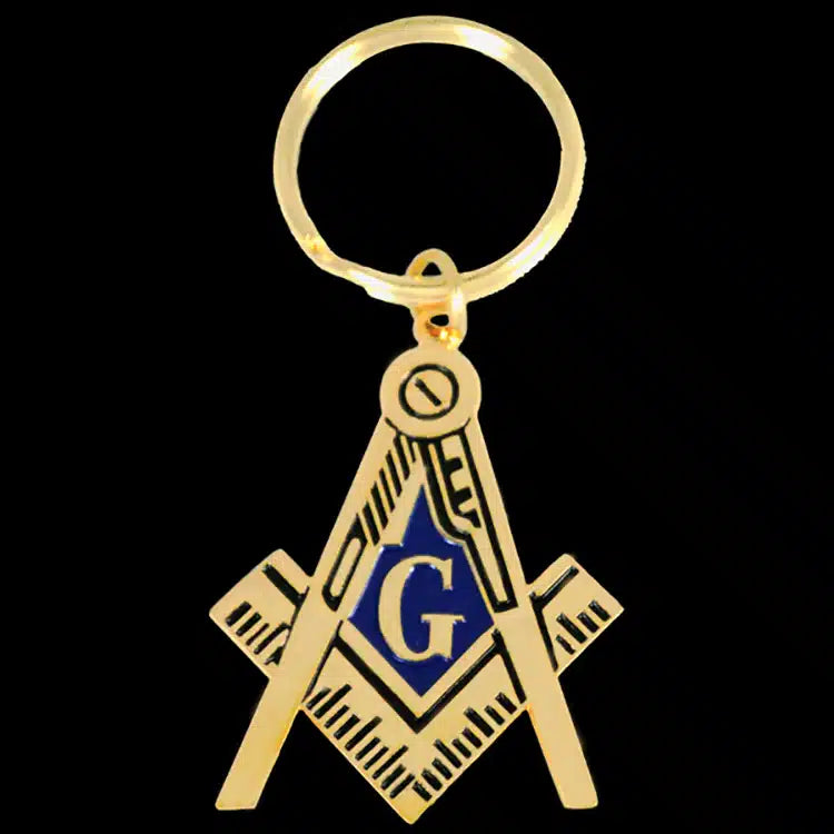 Gold Masonic keychain with blue 'G' on a black background