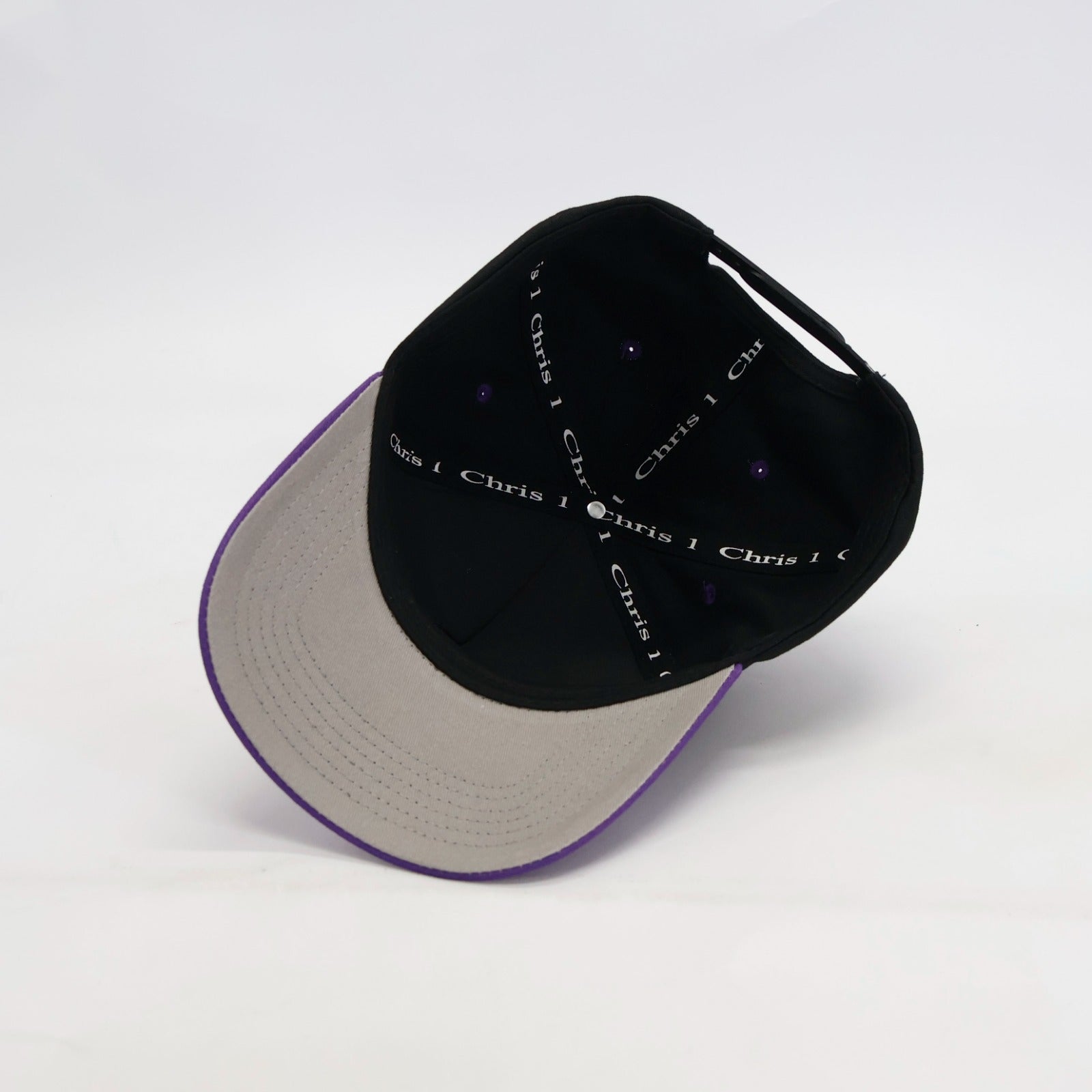 Black and beige cap with 'Chris' text on inner cap