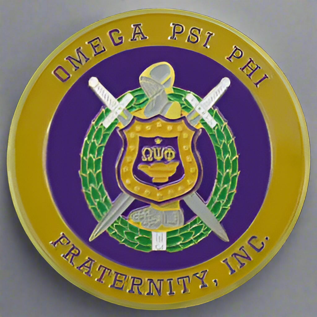 A car emblem featuring the Greek letters for Omega Psi Phi Fraternity, Inc. with a shield, sword, and wreath design.