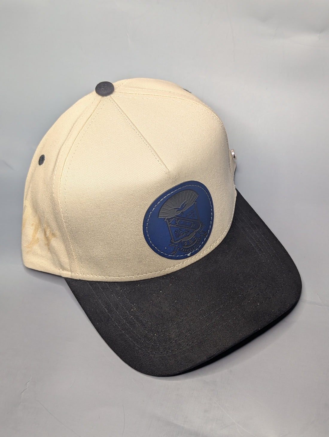 Two baseball caps with embroidered logos on a blue background, featuring the text '1914 Sigma Champions' and 'ChampionsPhate.com'.
