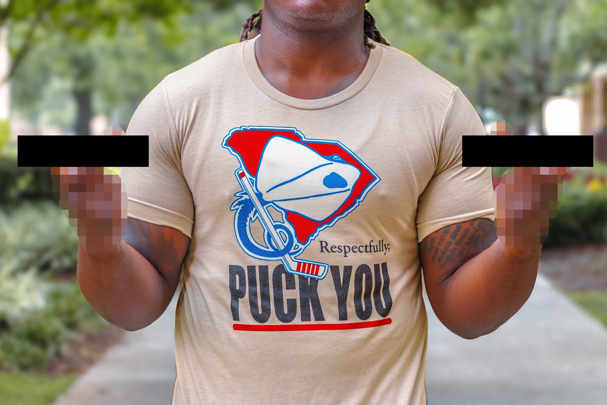 Person wearing a beige t-shirt with a graphic design and text outdoors.