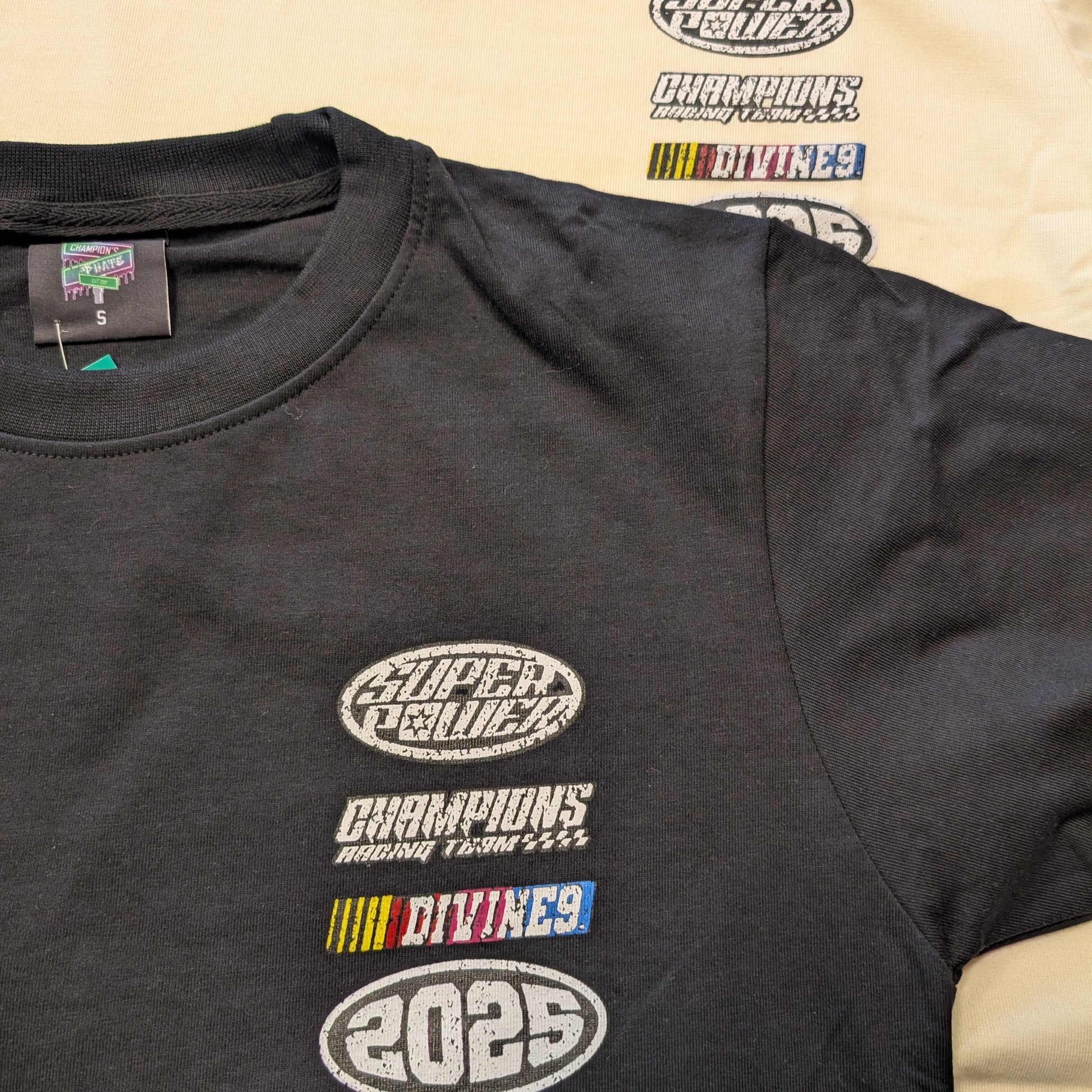 Black t-shirt with multiple logos on a beige background