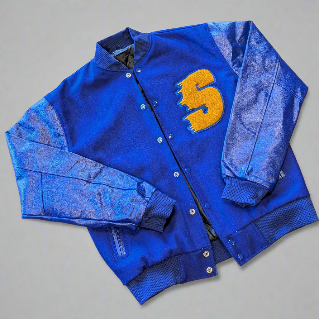 Blue varsity jacket with a yellow letter "S" on a wooden surface