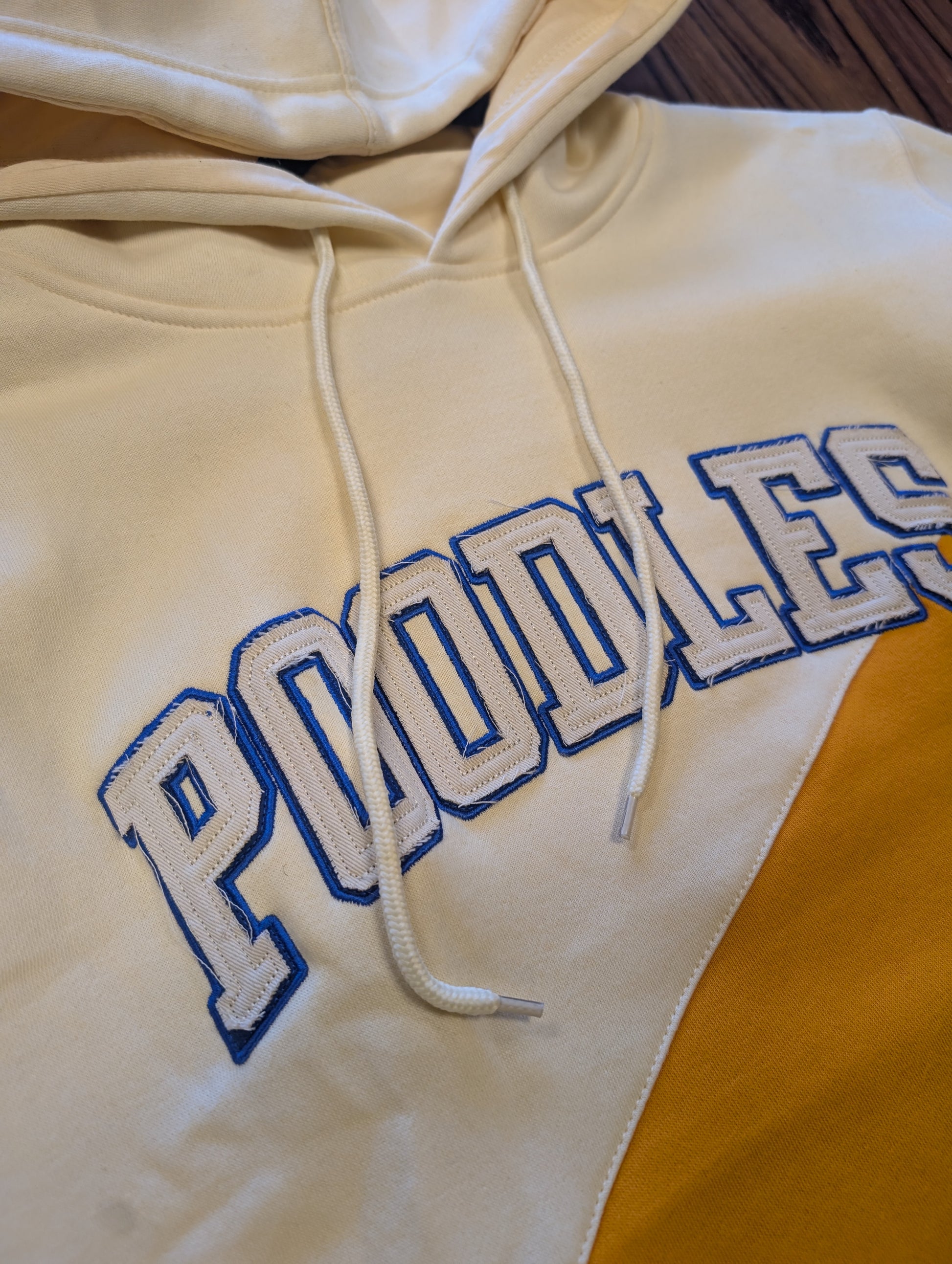 cream and yellow hoodie with "poodles" on chest