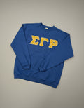 Blue sweatshirt with yellow greek letters sigma gamma rho on a gray background