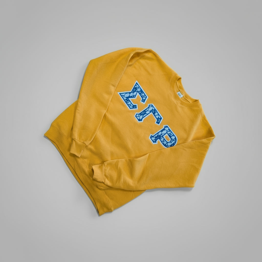 Yellow sweatshirt with blue lettering on a wooden surface