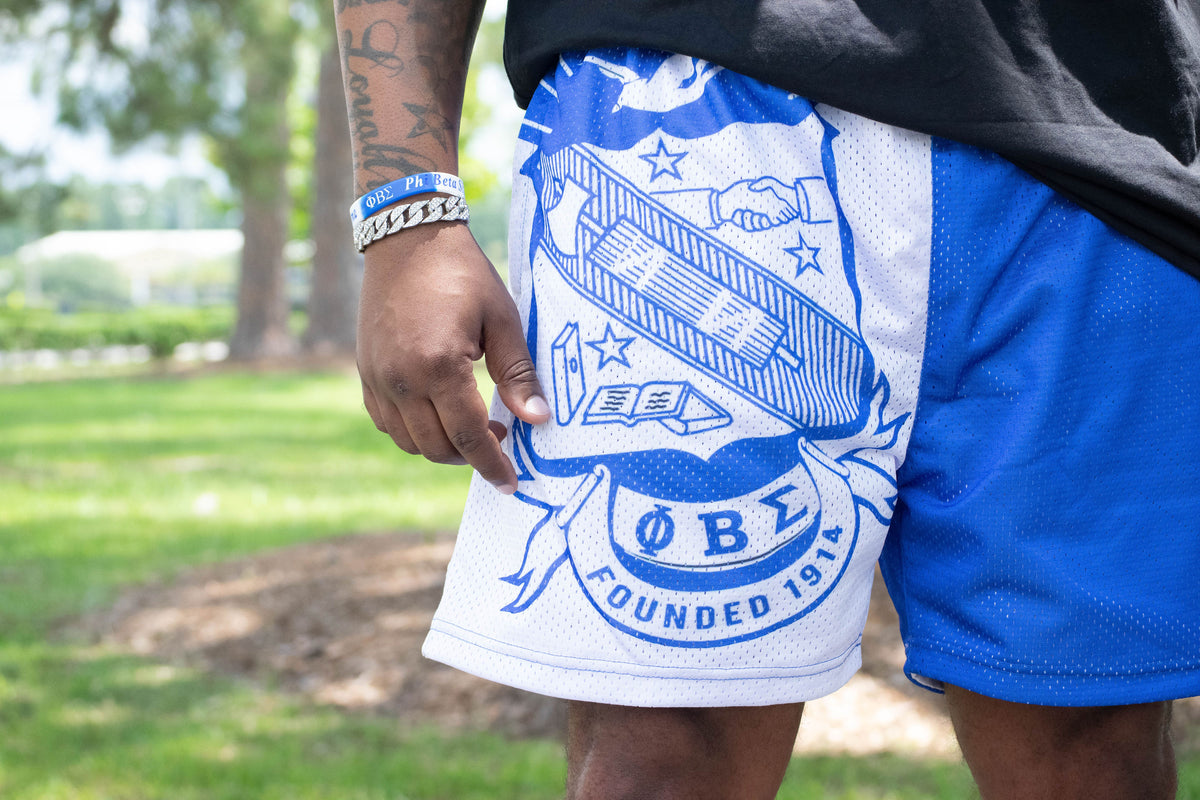 Person wearing blue shorts with a white emblem in an outdoor setting