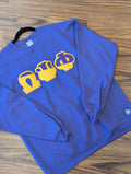 purple sweatshirt with yellow graphics on a gray surface