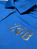 Blue polo shirt with metallic 'Zeta Phi Beta' greek letters on the left chest