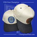 Two baseball caps with logos on a blue background, featuring text about 1920 Zeta Champions and a website address.