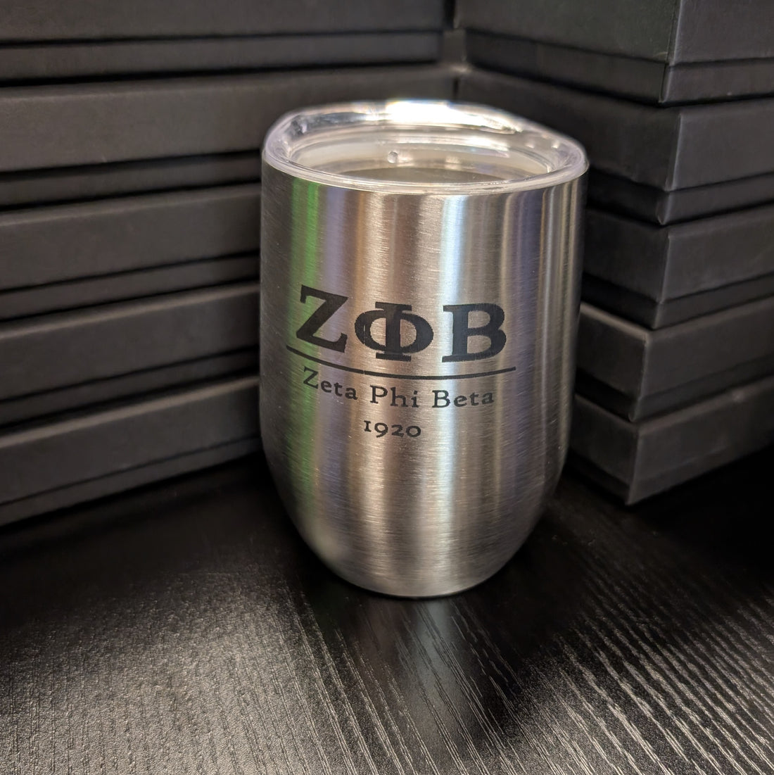 Silver tumbler with Zeta Phi Beta logo on a dark surface